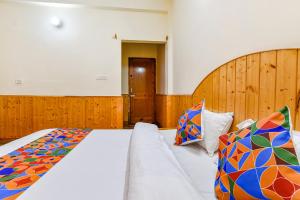 a bedroom with a large bed with a couch at FabHotel Suvidha Cottage in Manāli
