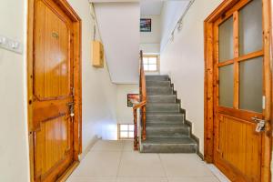 a staircase in a house with a wooden door at FabHotel Suvidha Cottage in Manāli