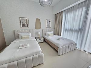 a hotel room with two beds and a window at Brand New Luxurious 2BR ACT Towers Downtown in Dubai