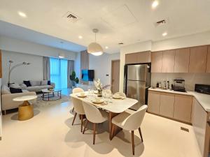 a kitchen and living room with a table and chairs at Brand New Luxurious 2BR ACT Towers Downtown in Dubai