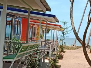 une maison colorée avec des chaises sur la plage dans l'établissement HomeState Bang Maprao, à Ban Hin Sam Kon