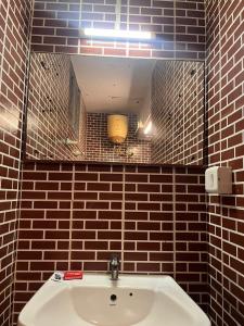 ein Badezimmer mit einem weißen Waschbecken und einem Spiegel in der Unterkunft THE ALP HOTEL Bypass Road in Madurai
