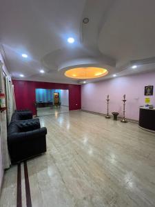 una sala de estar con sofá y una habitación con paredes moradas. en THE ALP HOTEL Bypass Road, en Madurai
