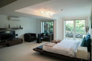 a bedroom with a bed and a flat screen tv at Beach House Resort Goa in Benaulim