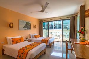 a hotel room with two beds and a balcony at Srisuksant Resort in Ao Nang Beach