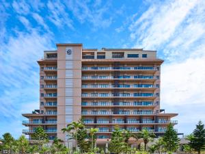 a tall building with a clock on it at Hotel Shigira Mirage Beach Front in Miyako Island