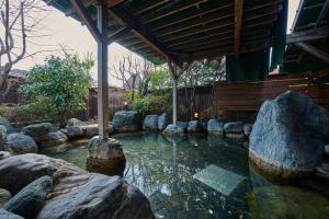 a pool of water with rocks in a garden at Royal Hotel Kawaguchiko in Fujikawaguchiko