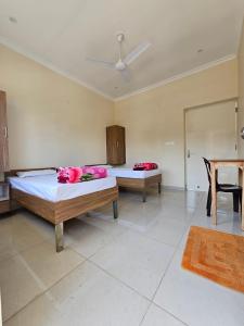 ein Zimmer mit 2 Betten mit rosa Blumen drauf in der Unterkunft swaastik stay in Rishikesh