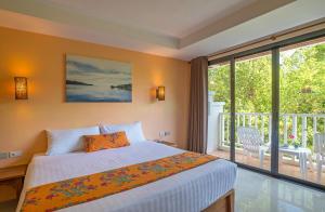 een slaapkamer met een bed en een balkon bij Srisuksant Resort in Ao Nang Beach