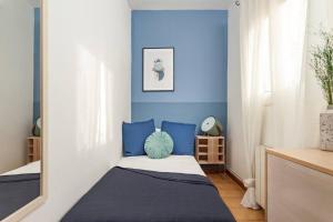 Schlafzimmer mit blauen Wänden und einem Bett mit blauen Kissen in der Unterkunft City View Penthouse - 2 Bedroom Suite in Barcelona