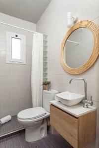 a bathroom with a toilet and a sink and a mirror at City View Penthouse - 2 Bedroom Suite in Barcelona