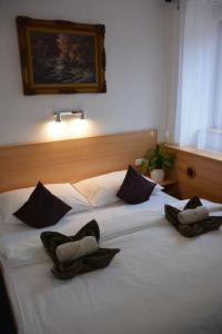 2 Betten in einem Hotelzimmer mit Hüten darauf in der Unterkunft Hotel O.K. 1 in Beroun