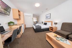 ein Hotelzimmer mit einem Bett und einem Schreibtisch in der Unterkunft Best Western Tuscany on Tor Motor Inn in Toowoomba