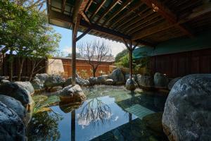 a pool of water with rocks in a yard at Royal Hotel Kawaguchiko in Fujikawaguchiko