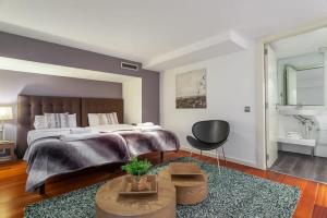 a bedroom with a large bed and a black chair at 3bedroom Duplex with balcony in plaza Cataluña in Barcelona