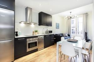 een keuken en een woonkamer met een tafel, een keuken en een eetkamer bij Bright and modern 2bedroom in Las Ramblas 2 1A in Barcelona