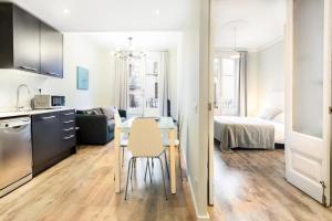 een keuken en een woonkamer met een tafel en een bed bij Bright and modern 2bedroom in Las Ramblas 2 1A in Barcelona