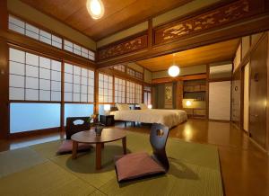 a bedroom with a bed and a table in a room at 貸切宿KUMANO in Miyazaki