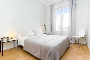 een witte slaapkamer met een groot bed en een raam bij Bright and modern 3bedroom in Las Ramblas 3 1B in Barcelona