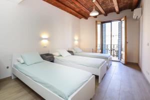 um quarto com 2 camas e uma grande janela em Huge and modern 4 bedroom apartment next to Paseo de Gracia em Barcelona