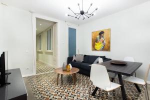 een woonkamer met een blauwe bank en een tafel bij Bright and modern 3bedroom in Las Ramblas 3 1B in Barcelona