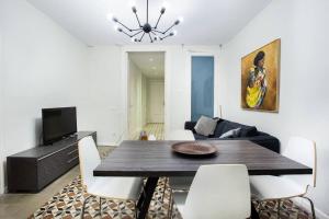 een woonkamer met een eettafel met witte stoelen bij Bright and modern 3bedroom in Las Ramblas 3 1B in Barcelona