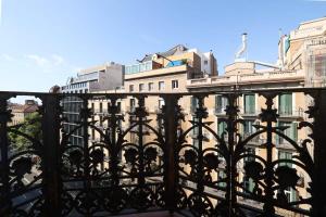 uma vista de um edifício por trás de uma cerca em Huge and modern 4 bedroom apartment next to Paseo de Gracia em Barcelona