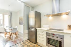 een keuken met een roestvrijstalen koelkast en een tafel bij 4bedroom apart with balcony in Las Ramblas 3-2 in Barcelona