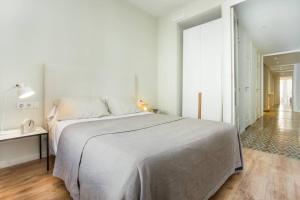 Un dormitorio blanco con una cama grande y una mesa en 4bedroom apart with balcony in Las Ramblas 3-2, en Barcelona