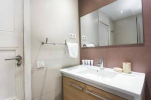 een badkamer met een witte wastafel en een spiegel bij 4bedroom apart with balcony in Las Ramblas 3-2 in Barcelona