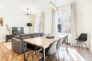4 bedroom apartment with a balcony in Las Ramblas 2 2 في برشلونة: غرفة معيشة مع طاولة وأريكة