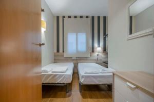 a hospital room with two beds and a mirror at Modern and bright apartment in Eixample 5-2 in Barcelona