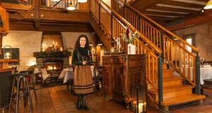a woman standing in a room with a staircase at Victor's Residenz-Hotel Schloss Berg in Nennig