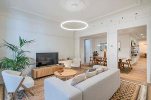 sala de estar con sofá blanco y TV en Amazing 5 bedrooms 5 bathrooms by Plaza Catalunya en Barcelona