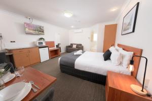 a hotel room with a bed and a kitchen at Best Western Tuscany on Tor Motor Inn in Toowoomba
