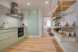 a kitchen with green cabinets and wooden floors at Amazing 5 bd 5 bathroom next to Plaza Catalunya in Barcelona