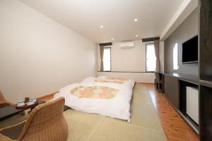 a bedroom with a bed and a television in it at Royal Hotel Kawaguchiko in Fujikawaguchiko