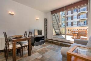 a living room with a desk and a table and a window at 3BD with private terrace right by Sagrada Familia in Barcelona