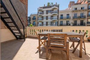 a wooden table and chairs on a balcony with a building at 3BD with private terrace right by Sagrada Familia in Barcelona