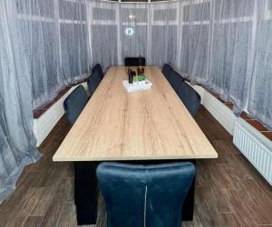 Cosy 4 Bed House في ألدرشوت: قاعة اجتماعات مع طاولة خشبية وكراسي زرقاء
