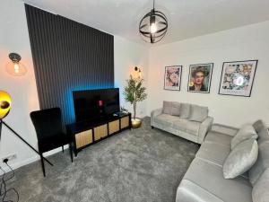 - un salon avec un canapé et une télévision dans l'établissement Cosy 4 Bed House, à Aldershot