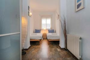 a small room with two beds and a window at 3BD with private terrace right by Sagrada Familia in Barcelona
