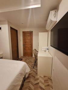 1 dormitorio con 1 cama, TV y escritorio en Casa Ison Hotel en Sablayan