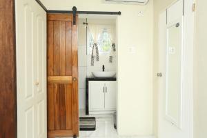 baño con lavabo y puerta de madera en Hidden gem en Kingston