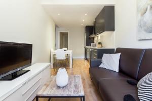 Centric 2bedroom in Las Ramblas 3 1A في برشلونة: غرفة معيشة مع أريكة وطاولة