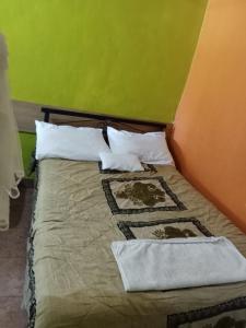 un letto in una camera con parete verde di Yaya kilimani cottage B a Nairobi