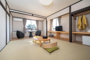 a room with a table and chairs and a desk at Royal Hotel Kawaguchiko in Fujikawaguchiko