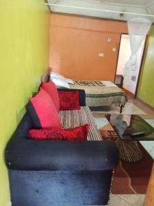 a living room with a couch and a bed at Yaya kilimani cottage B in Nairobi