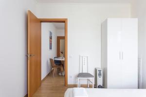 1 dormitorio con una puerta que da a una mesa y una silla en Sunny 3BD apartment in Poblenou next to the beach, en Barcelona