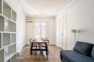 uma sala de estar com uma mesa e um sofá em Historic Catalan 4BD apartment in Gran Vía em Barcelona